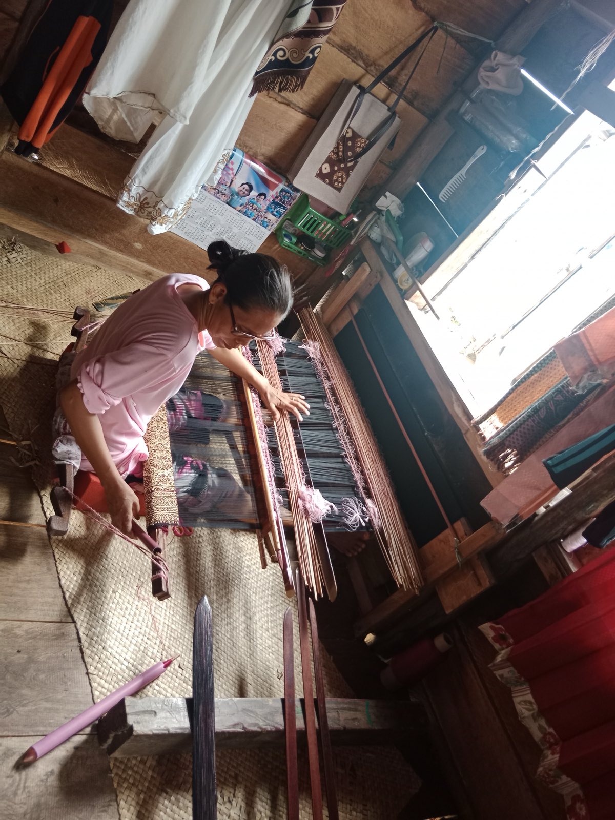A weaver working gold supplementary-weft songket at a traditional loom in Palembang, South Sumatra.